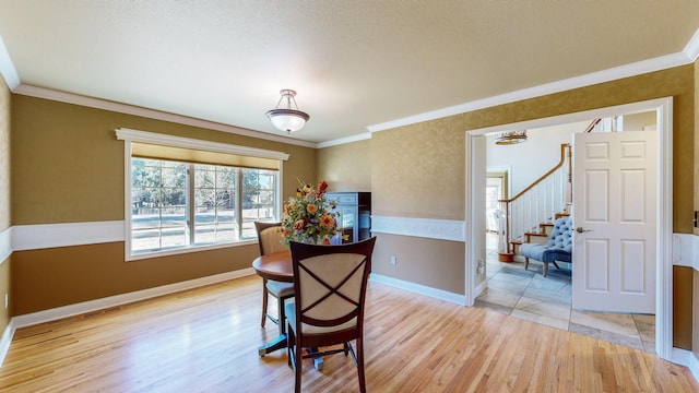 dining room featuring ornamental molding and light wood-type flooring