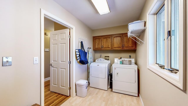 washroom featuring cabinets, washer and dryer, and light wood-type flooring