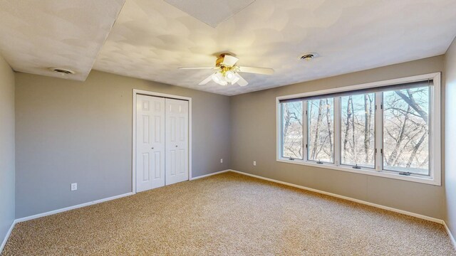 unfurnished bedroom featuring a closet, ceiling fan, and carpet