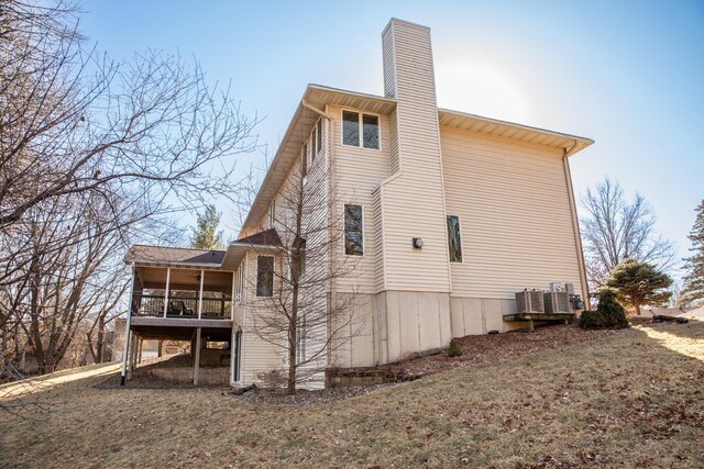 back of house featuring a lawn and central air condition unit