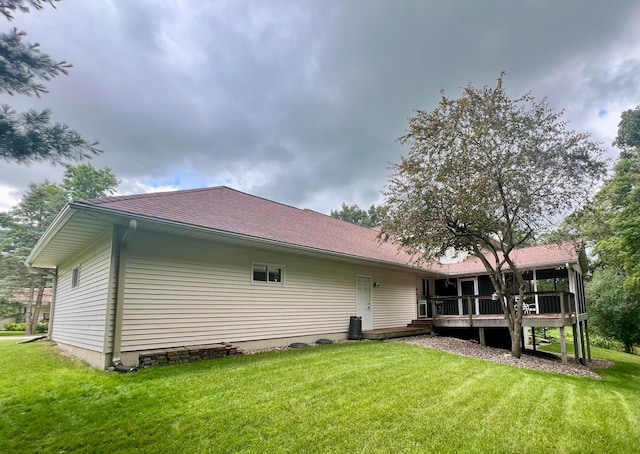 rear view of property featuring a yard and a deck