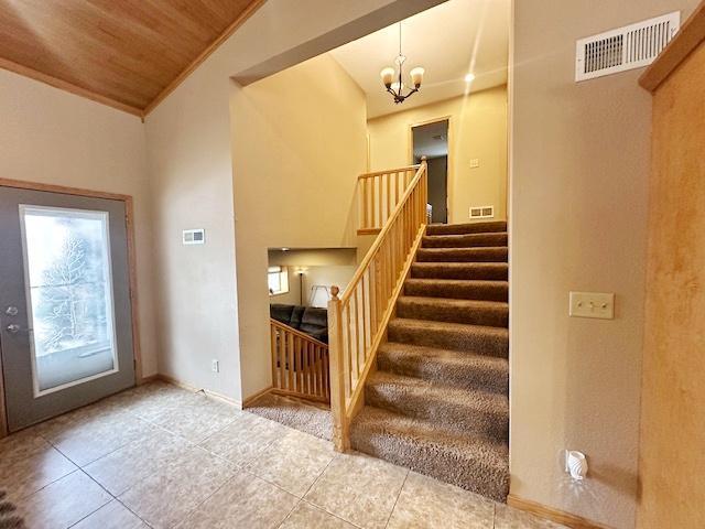 112 Bay Rd, Coleraine, MN 55722 - stairway with tile patterned floors, a chandelier, baseboards, wood ceiling, and lofted ceiling