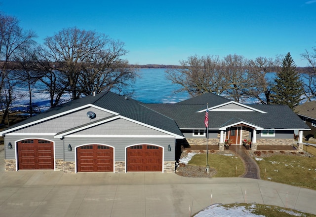 view of front of property featuring a water view, a garage, and a front yard