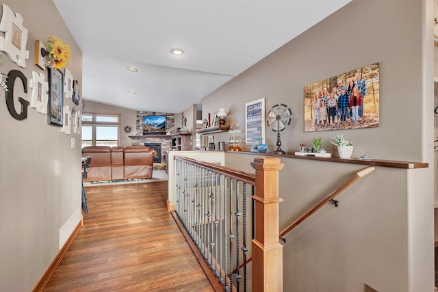 hallway with wood-type flooring and lofted ceiling