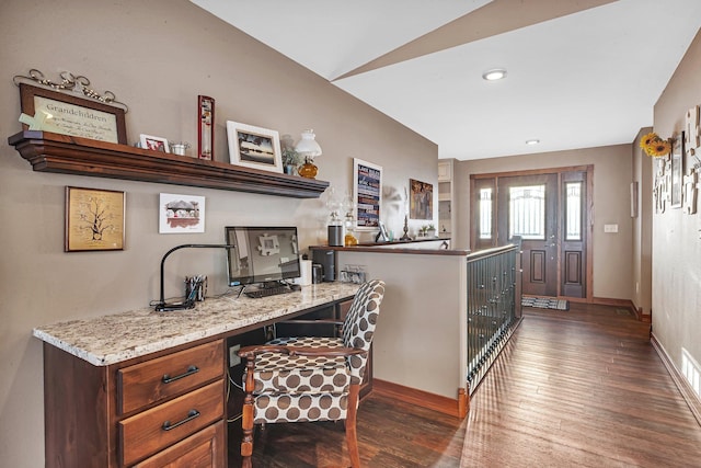 office space featuring built in desk, dark hardwood / wood-style floors, and vaulted ceiling