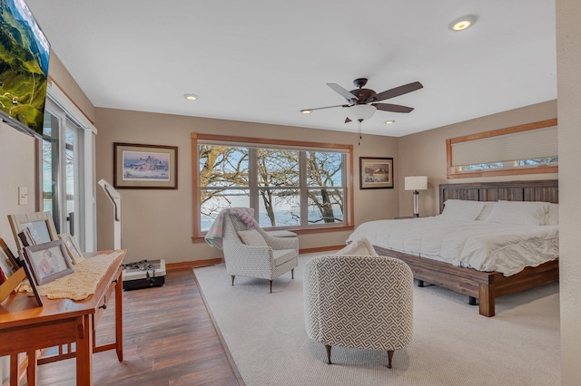 bedroom featuring hardwood / wood-style flooring, ceiling fan, and multiple windows