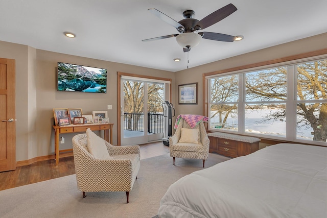 bedroom featuring access to exterior, light hardwood / wood-style floors, and ceiling fan