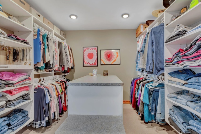 walk in closet with light carpet