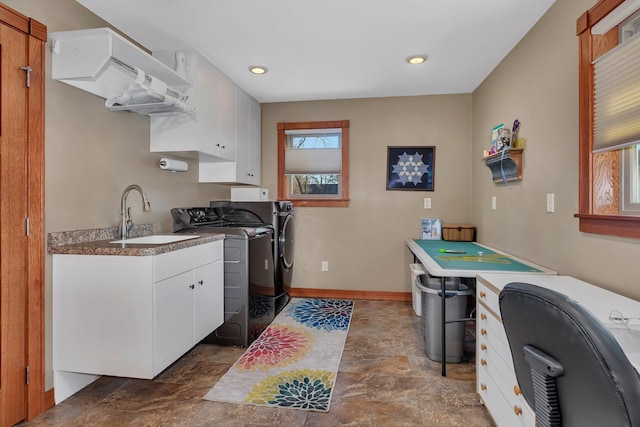 kitchen featuring white cabinetry, sink, and washing machine and clothes dryer