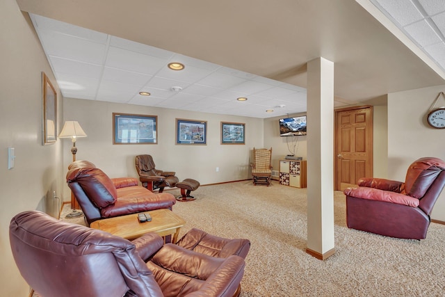 living room with a paneled ceiling and carpet flooring