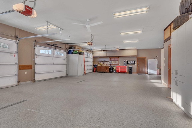 garage with a garage door opener and white refrigerator