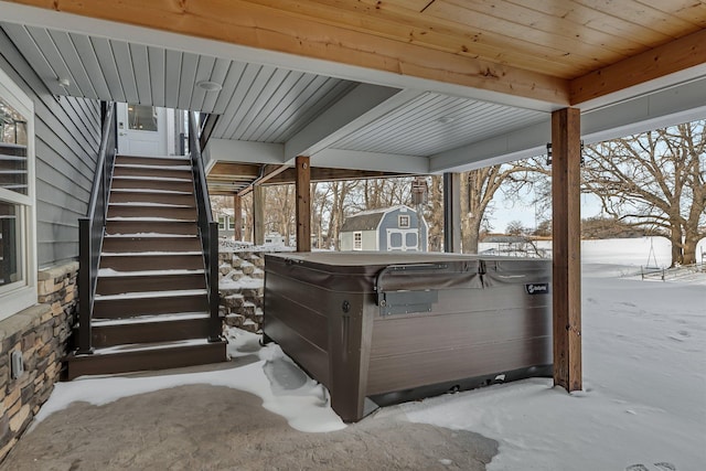 snow covered patio with a hot tub