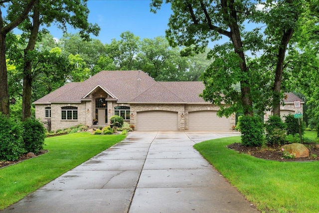 view of front of property featuring a shingled roof, a garage, stone siding, driveway, and a front lawn