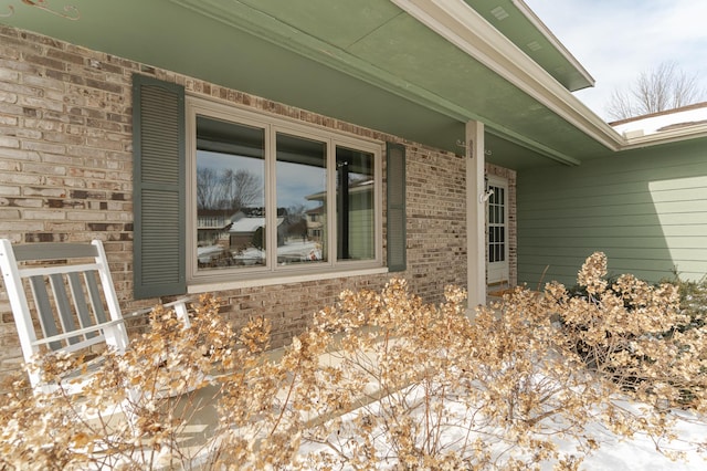 view of snow covered exterior featuring brick siding