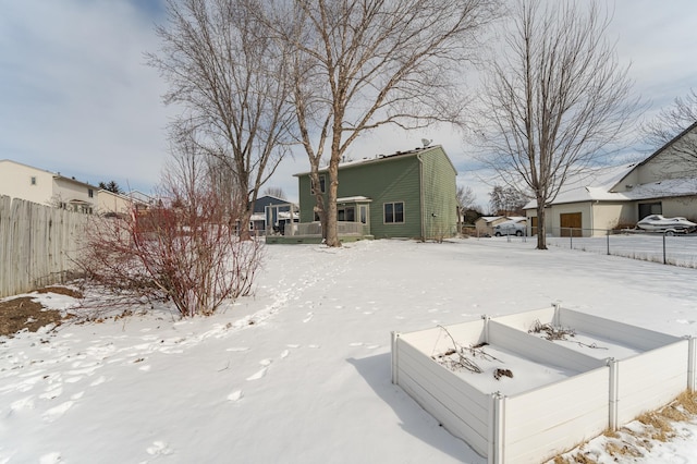 snow covered house with fence and a residential view