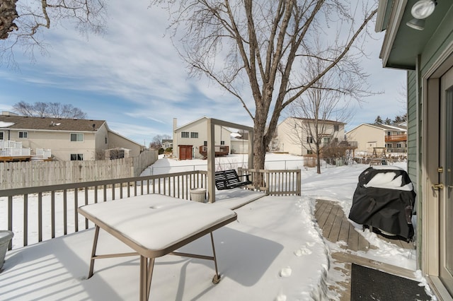 snow covered deck featuring fence and a residential view