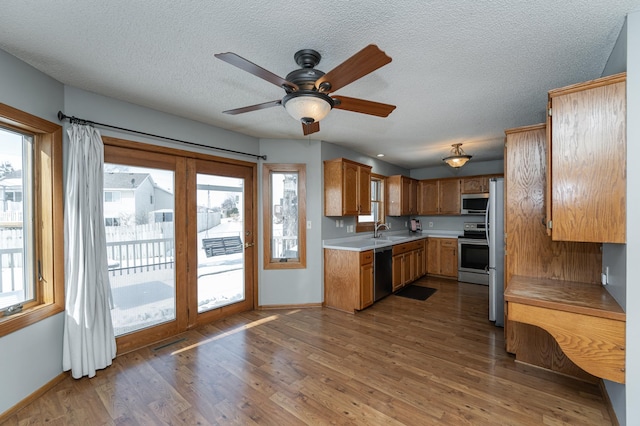 kitchen with dark wood-style floors, stainless steel appliances, plenty of natural light, and light countertops