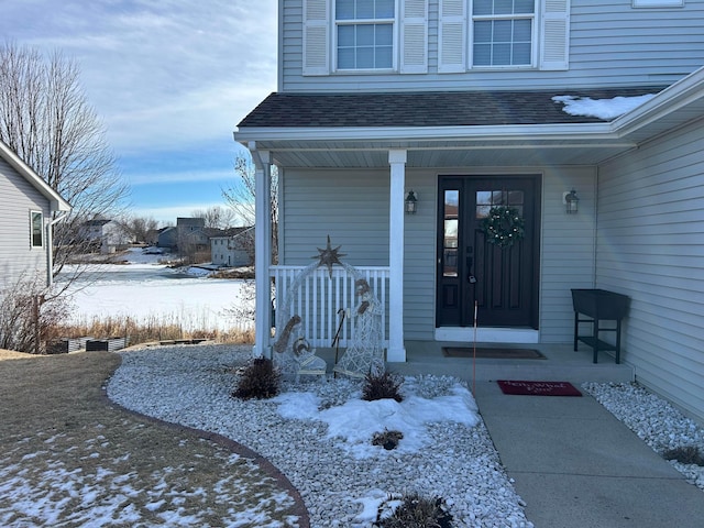 snow covered property entrance featuring covered porch