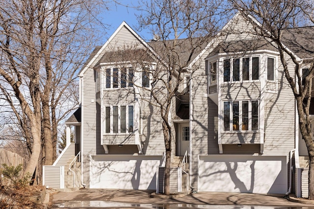 view of front of property featuring a garage, driveway, and stairway