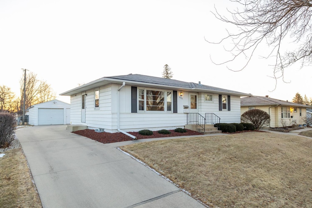 ranch-style house with a garage, an outdoor structure, and a front yard