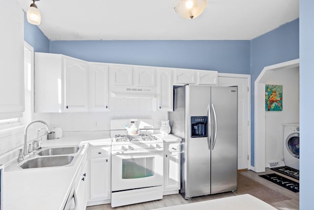 kitchen with washer / dryer, sink, white cabinets, stainless steel fridge with ice dispenser, and white gas stove