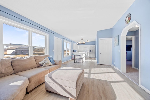 living room featuring an inviting chandelier and light hardwood / wood-style flooring