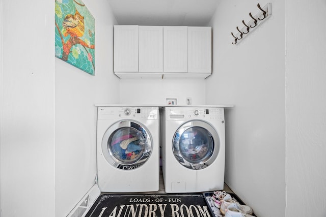 clothes washing area featuring cabinets and washing machine and clothes dryer