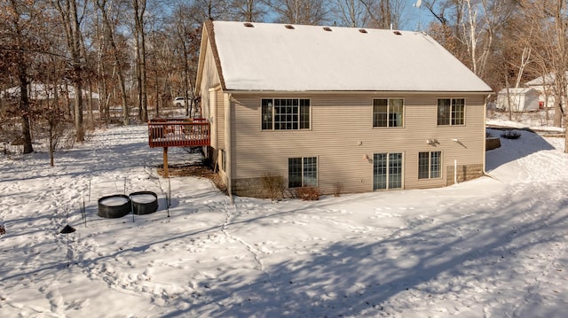 snow covered house with a wooden deck