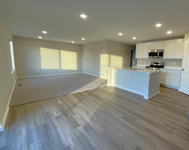 kitchen with white cabinetry, appliances with stainless steel finishes, sink, and light wood-type flooring