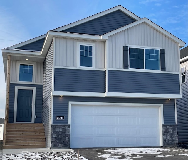 view of front of property with entry steps, stone siding, a garage, and board and batten siding