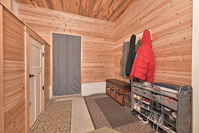 mudroom with wooden ceiling and wooden walls