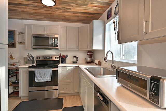 kitchen featuring lofted ceiling, sink, wood ceiling, light hardwood / wood-style floors, and stainless steel appliances