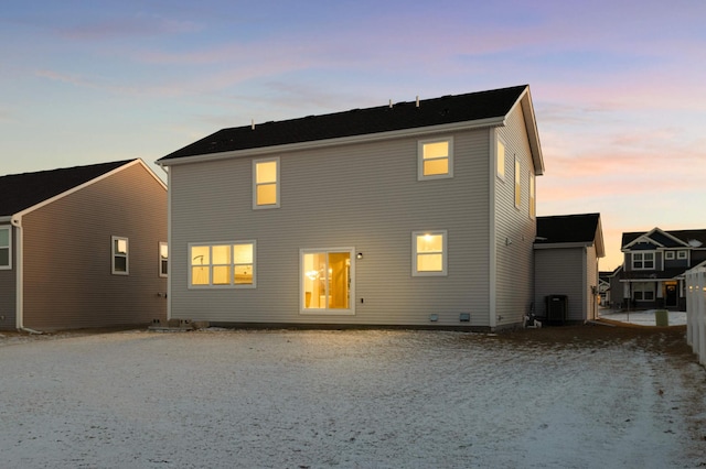 back house at dusk featuring central air condition unit