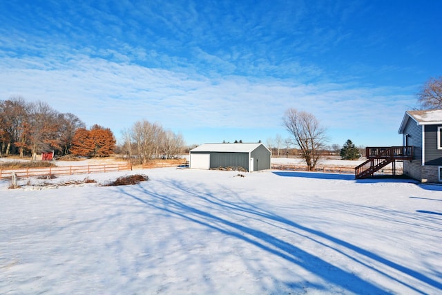 yard covered in snow featuring a wooden deck and an outbuilding