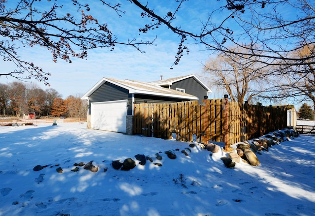 view of snowy exterior with a garage