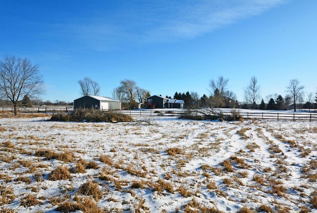 yard layered in snow featuring a rural view and an outdoor structure