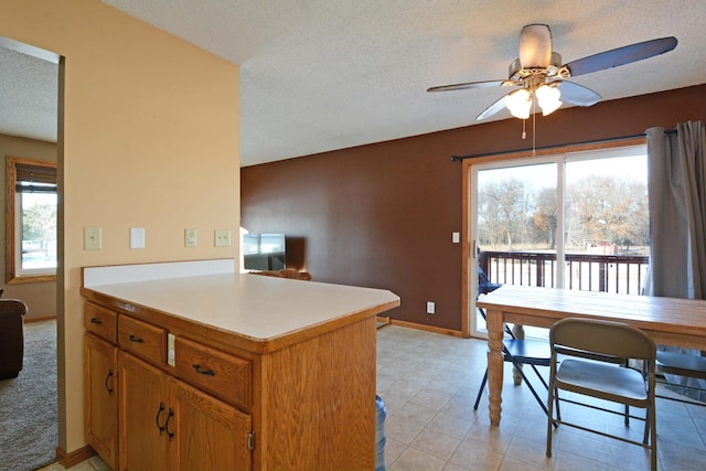 kitchen featuring plenty of natural light, a textured ceiling, ceiling fan, and kitchen peninsula