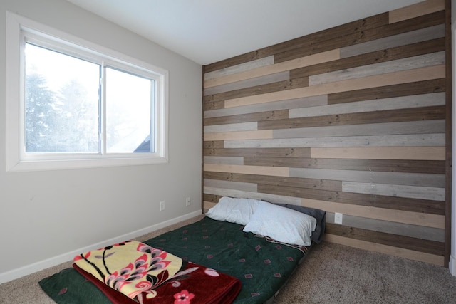 bedroom with carpet flooring and wooden walls