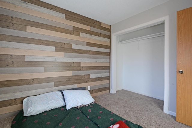 unfurnished bedroom with carpet floors, a closet, and wood walls