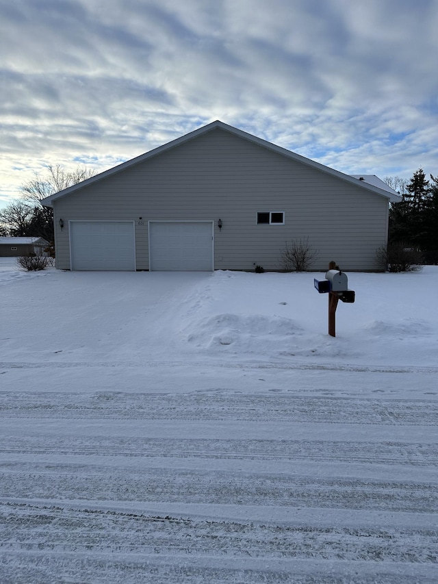 view of snow covered exterior featuring a garage