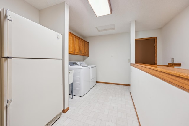 laundry room with attic access, cabinet space, baseboards, and separate washer and dryer