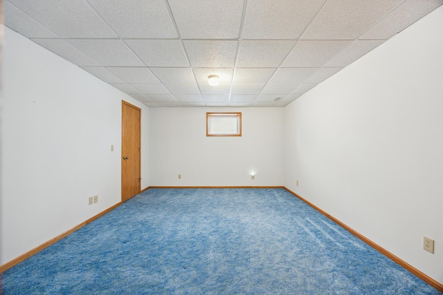 unfurnished room featuring carpet floors, a drop ceiling, and baseboards