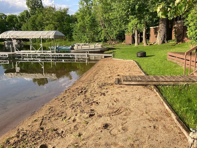 dock area featuring a water view and a lawn