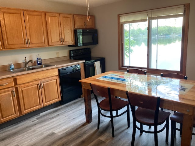 kitchen with decorative light fixtures, sink, dark hardwood / wood-style floors, and black appliances