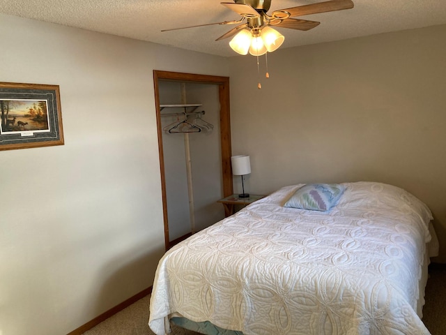 carpeted bedroom with ceiling fan, a closet, and a textured ceiling