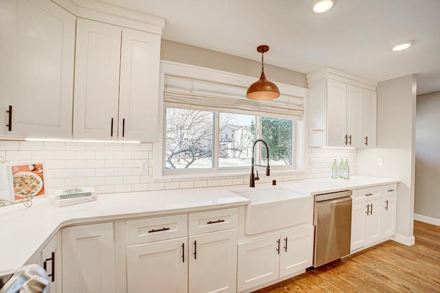 kitchen featuring white cabinetry, decorative light fixtures, dishwasher, and sink