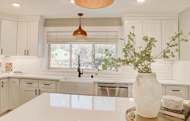 kitchen featuring white cabinets, hanging light fixtures, sink, and dishwasher