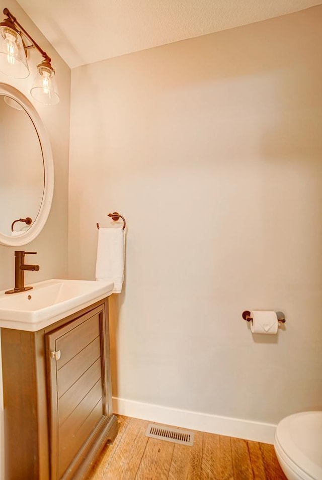 bathroom featuring hardwood / wood-style flooring, vanity, and toilet