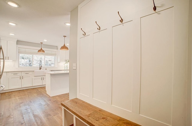 mudroom featuring sink and light wood-type flooring