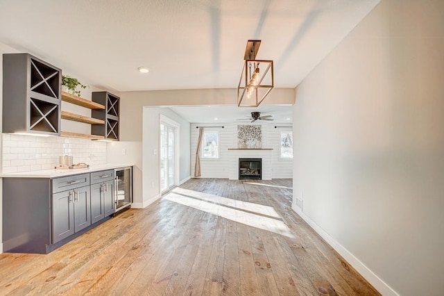 interior space with wine cooler, light hardwood / wood-style floors, ceiling fan, and indoor bar